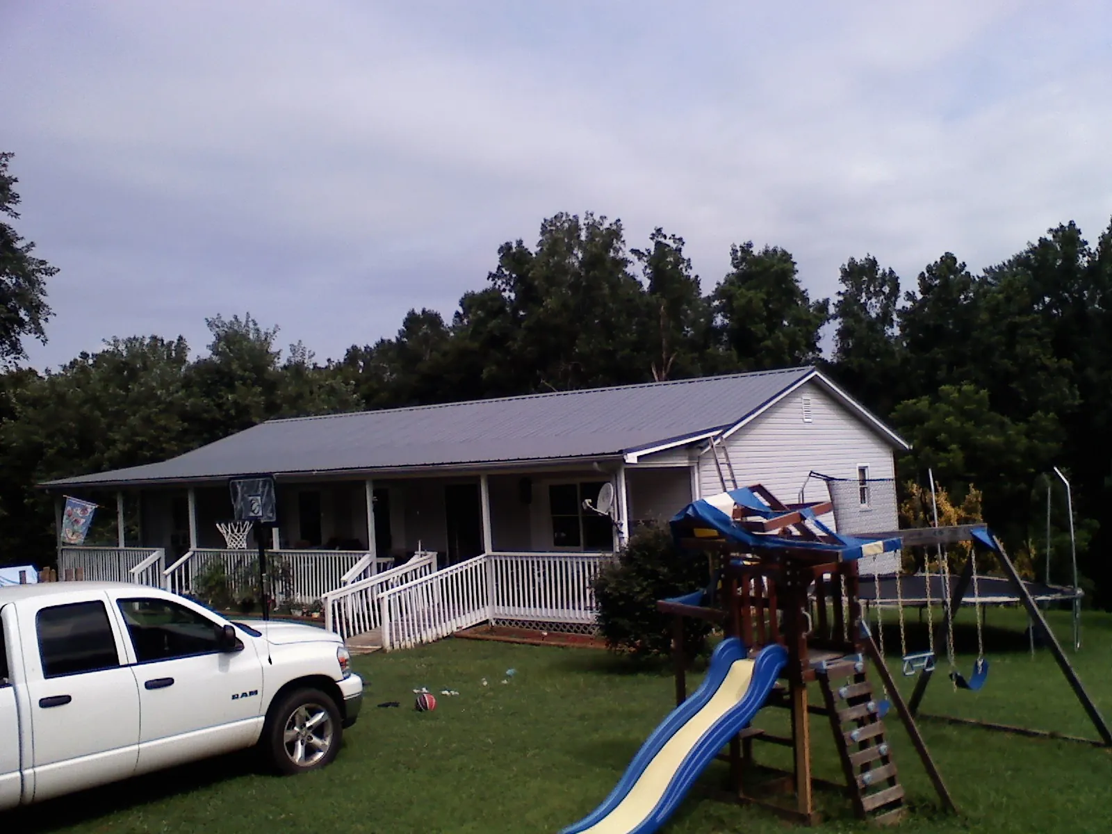 Dark metal roof on a country home with a full length front porch in Chester
